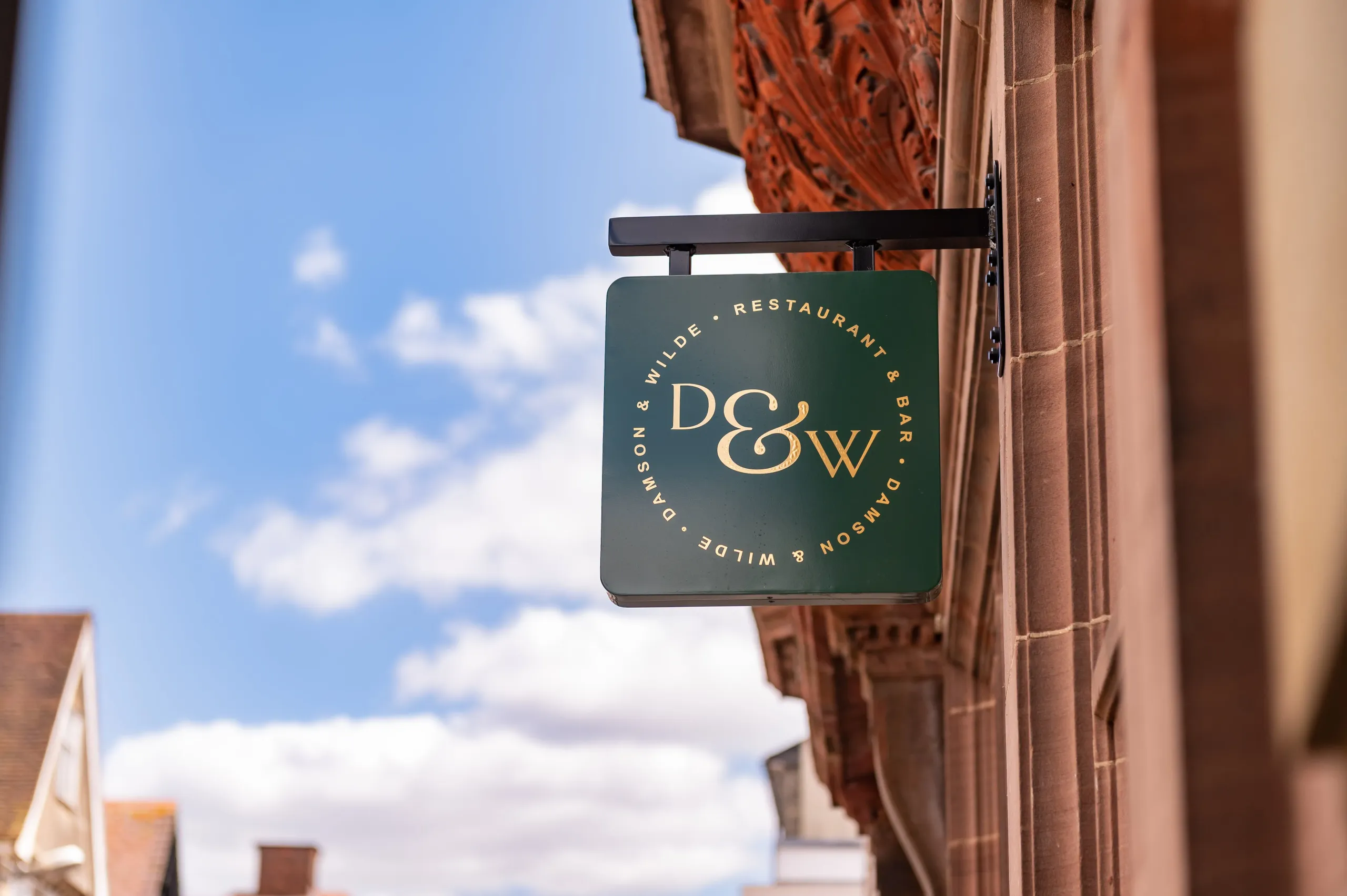 The Damson & Wilde hanging sign outside the Abbeygate Street brasserie